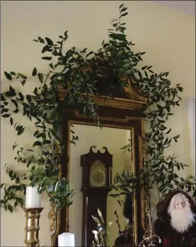  ?? BETTY MONTGOMERY ?? Smilax above a mirror adds a festive touch.