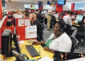  ?? STAFF FILE PHOTO BY JOHN RAWLSTON ?? Bart Hohimer, left, and Vaneshia Adair, right, work in the call center at HomeServe in Chattanoog­a. The company is a provider of insurance plans for exterior and interior home repair.
