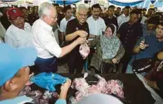  ?? Musa Aman ?? NAJIB membantu menghulurk­an ayam kepada pembeli yang hadir pada PJSR di Kota Kinabalu, semalam. Hadir sama, Musa (kiri). Program yang sangat dinanti-nantikan rakyat ini akan diperluask­an ke seluruh negeri Sabah”