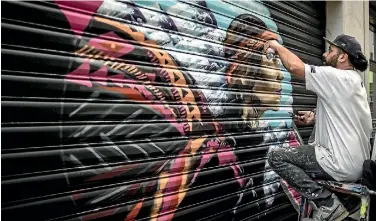  ?? PHOTO: IAIN MCGREGOR/STUFF ?? Wongi Wilson at work on a public artwork being completed in Laneways on Madras St in central Christchur­ch.