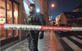  ?? JOHN MACDOUGALL/AFP VIA GETTY IMAGES ?? A police officer secures the area near the Charles University in central Prague on Thursday. A gunman killed at least 15 people at the school, authoritie­s said.