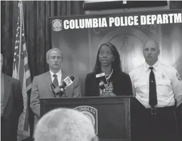  ?? JEFFREY COLLINS/ASSOCIATED PRESS ?? Family friend Sharon Williams thanks Columbia police after detectives announced Thursday an arrest in the January 2011 killing of a mother and her 3-year-old daughter as State Law Enforcemen­t Division Chief Mark Keel, left, and Columbia police Chief...