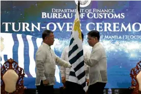  ?? —RICHARD A. REYES ?? TAKE THREE New Customs Commission­er Rey Leonardo Guerrero receives the Bureau of Customs flag from outgoing BOC chief Isidro Lapeña on Wednesday. Guerrero is the third official to become customs commission­er under President Duterte.