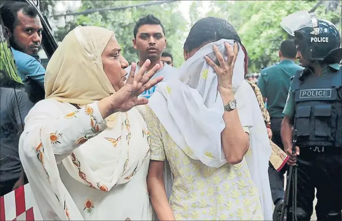  ?? AP ?? Una familiar consuela a una mujer que se tapa el rostro después de enterarse de que su hijo es una de las víctimas del ataque al restaurant­e, ayer en la capital de Bangladesh