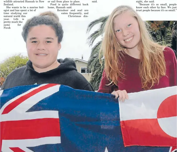  ?? Photo: ANDREA O’NEIL ?? Kiwi meets Inuit: Greenland exchange student Hannah Christians­en, right, holds the Greenlandi­c flag her great-uncle designed. She is with her Ranui host sister Sia McKinley.