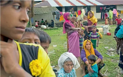  ?? AP ?? Rohingya rest after crossing over to the Bangladesh side of the border near Cox’s Bazar’s Teknaf area. —