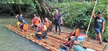  ?? ?? a group posing to mark the end of their bamboo rafting journey.