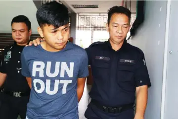  ??  ?? The accused is escorted by police from the court after he was charged with possession of counterfei­t notes.