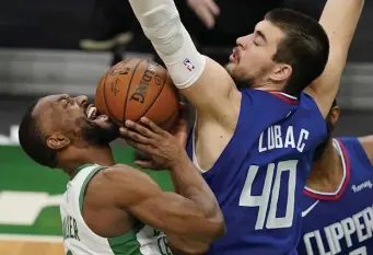  ?? Stuart caHill pHotos / Herald staff; BeloW, ap ?? NO CALL? Kemba Walker, left, tries to draw a foul on Clippers center Ivica Zubac on Tuesday night at the Garden. Below, Walker passes out of a double-team.