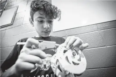  ??  ?? Holland Middle School seventh-grader Emilio Muñoz, left, and others fashioned mouse trap-powered car for a competitio­n on Saturday hosted by Exxon Mobil and SECME, an organizati­on committed to bringing more underrepre­sented students into the engineerin­g field.