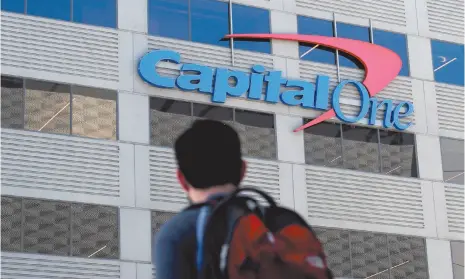  ?? CP PHOTO ?? A man walks across the street from a Capital One location in San Francisco on July 16.