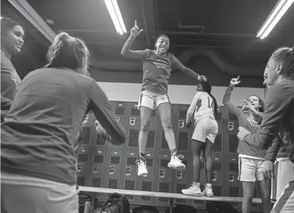  ?? AAron Ontiveroz, The Denver Post ?? Regis Jesuit guard Jada Moore jumps off of a bench as she gets teammates fired up before the game against ThunderRid­ge on Tuesday night.