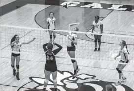  ?? Photos by TIM GODBEE / For the Calhoun Times ?? ( Calhoun’s Anna George (center) rises up for a kill against Woodland as her teammates provide support on Thursday. ( Calhoun’s Emma Kate Smith gets ready to send the ball back over the net vs. LaFayette.