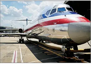  ?? Bloomberg ?? An American Airlines MD-80 aircraft sits at a gate Sunday at Dallas/Fort Worth Internatio­nal Airport. On Wednesday, after 36 years, the airline made its last MD-80 commercial trip, flying from Dallas to Chicago.