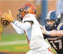  ?? JONATHON GRUENKE/STAFF ?? Churchland’s Na’Shawn Bunch, left, gets past Maury’s Patrick McDowell to convert a two-point conversion during an April 1 game at Powhatan Field. Both teams made the playoffs and begin their postseason on Friday night.