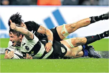  ??  ?? At the double: George Bridge, Barbarians’ Kiwi outside-back, shrugs off Ardie Savea for one of his two tries against his countrymen