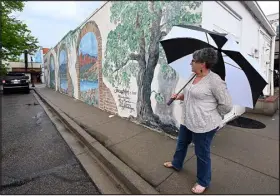  ?? JENNY SPARKS — REPORTER- HERALD ?? Jill Atchison, director of the Lincoln Gallery and Thompson Valley Art League, talks about the mural that has been on the building since 2001 in downtown Loveland.