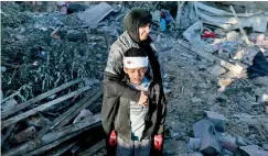  ?? ?? A Palestinia­n woman embraces an injured boy as they check the rubble of a building following Israeli bombardmen­t, on Thursday in Rafah in the southern Gaza Strip. AFP