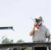  ?? ?? Byron Haire, area fire management officer for Area 8 of the Georgia Forestry Commission, radios his crew from the dock at St. Catherine’s Island. Haire and his crew are battling four fires on the island that were caused by lightning strikes earlier this month.