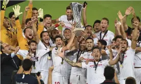 ??  ?? Jesús Navas, surrounded by his Sevilla teammates, lifts the Europa League trophy after the victory over Internazio­nale. Photograph: Ina Fassbender/AP