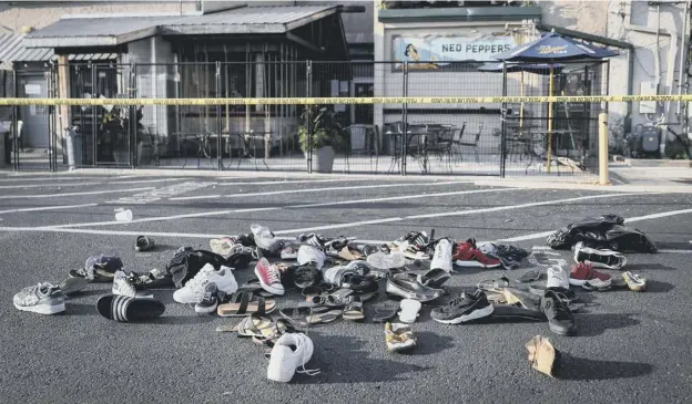 ??  ?? 0 Shoes lost by people fleeing the gunman who killed nine people in Dayton, Ohio, lie outside Ned Peppers bar yesterday