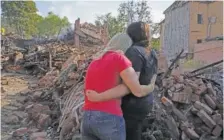  ?? AP PHOTO/ANDRII MARIENKO ?? Ukrainian women hug Aug. 18 in front of a building destroyed during a missile strike in Kharkiv, Ukraine.