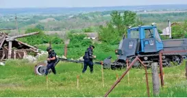  ?? (AFP) ?? Ukrainian deminers use a mine trawl to clear a field of landmines laid by Russian troops near the city of Balakliya in the Kharkiv region on Friday