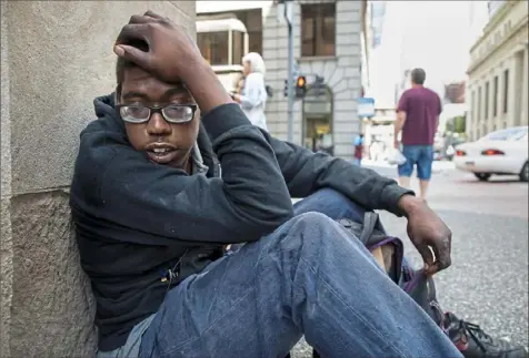  ?? Jessie Wardarski/Post-Gazette photos ?? CJ Brown, 25, originally of East Liberty, sits on a street corner Downtown and asks for money Sept. 4. Mr. Brown says he’s been homeless for about two years.