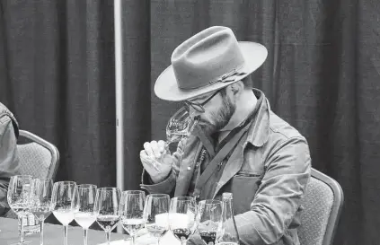  ?? Houston Livestock Show and Rodeo ?? A judge evaluates a wine at the 2019 edition of the Rodeo Uncorked! Wine Competitio­n.