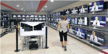  ?? Picture: BLOOMBERG ?? SAVING BE DAMNED: A customer browses flat-screen TVs inside an Electronik­i household appliance store in Thessaloni­ca, northeaste­rn Greece. Panic buying has gripped the country