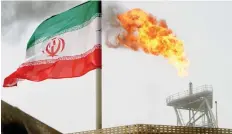  ?? — Reuters ?? A gas flare on an oil production platform in the Soroush oil fields is seen alongside an Iranian flag in Iran.