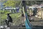  ?? HEATHER KHALIFA/THE PHILADELPH­IA INQUIRER VIA AP ?? Indigo, 20, a former Temple University global studies student, sits on a swing at the encampment at Ridge Avenue and Jefferson Street in North Philadelph­ia on Tuesday, Aug. 18.