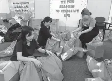  ??  ?? Clockwise from top: Migrant workers settle into new surroundin­gs at a dormitory transforme­d into an isolation area to prevent the spread of COVID-19 in Singapore. Staff members from the National Volunteer and Philanthro­py Centre prepare aid packages for ROSLAN RAHMAN / AFP healthcare workers. Medical personnel help a migrant worker into an ambulance at a dormitory in Singapore. PROVIDED TO CHINA DAILY EDGAR SU / REUTERS