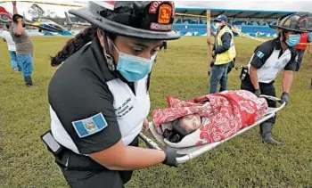  ?? MOISES CASTILLO/AP ?? Guatemalan rescue: A girl is carried to a waiting ambulance Saturday in San Cristobal Verapaz, where residents are believed buried by a massive, rain-fueled landslide in the aftermath of Tropical Storm Eta. Rescue teams first had to overcome landslides and deep mud just to reach the site where officials estimate some 150 homes were devastated.