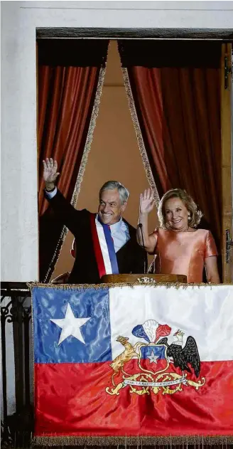  ?? Rodrigo Garrido/Reuters ?? Sebastián Piñera e a mulher, Cecilia Morel, acenam da varanda do Palácio de La Moneda