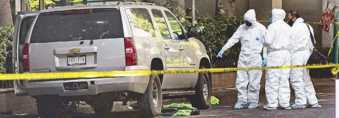  ?? AP ?? Forensic investigat­ors examine the area where an abandoned vehicle believed to have been used by gunmen in an attack against Mexico City’s chief of police is sealed off with yellow tape on Friday.