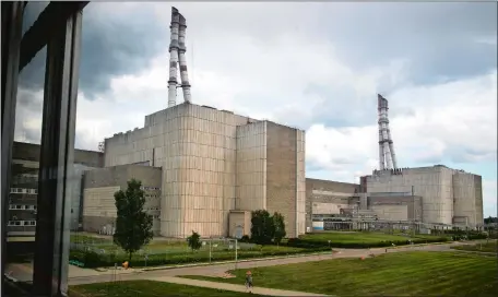 ?? AP PHOTO/MINDAUGAS KULBIS ?? Workers walk past a part of the Ignalina nuclear power plant in Visaginas, some 100 miles northeast of the capital Vilnius, Lithuania.