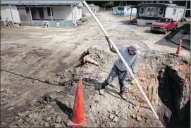  ??  ?? Ricardo Gomes feeds PVC pipe into a sewer line to pump out water while workers dig new sewer lines. Leaking pipes had left the park’s previous owners with a $51,000 utility bill.