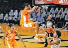  ?? AP PHOTO/MARK HUMPHREY ?? Tennessee’s Keon Johnson dunks over Vanderbilt’s Braelee Albert, right, in the second half of Wednesday night’s game in Nashville. The 25th-ranked Vols won 70-58, but Johnson had as many turnovers as points, with six of each.