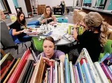  ?? Kim Brent/Staff file photo ?? Librarian Tayna Burges sorts books at Oak Forest Elementary in Vidor. HB 900 requires book vendors to rate titles for content.