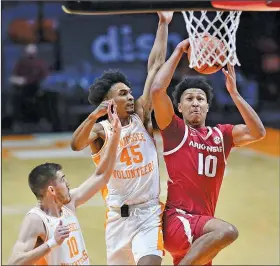  ?? Associated Press ?? Taking aim: Arkansas' Jaylin Williams (10) attempts to score while guarded by Tennessee's Keon Johnson (45) and John Fulkerson (10) during an NCAA college basketball game Wednesday in Knoxville, Tenn. The Volunteers rallied for a 79-74 win over the Razorbacks.