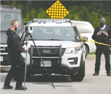  ?? NICK PROCAYLO ?? Police probe the 9700 block of 161A Street in Surrey, the scene of the fatal shooting of 20-year-old Keryane Arsenault on Tuesday.