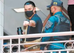  ?? FOTO: DAVID ROMERO ?? Marco Bográn es custodiado por un efectivo de Fuerzas Especiales de la Policía Nacional al ingresar a los tribunales de justicia.