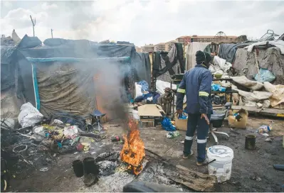  ?? Picture: Jacques Nelles ?? Residents of an informal settlement along the Hennops River in Centurion keep warm by a fire as the cold front continues in Gauteng yesterday.