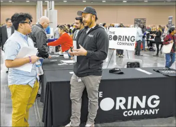  ?? ?? Darrell Lampa, right, a recruiter at the Boring Company, talks to a job seeker during the annual Spring Job Fair at the Las Vegas Convention Center on March 8.