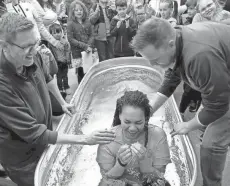  ?? SARAH PHIPPS/THE OKLAHOMAN PHOTOS BY ?? Top: The Rev. Jonathan Meyer and the Rev. Justin Bangert baptize Dominique Armstrong during the Baptism Bash and Easter Egg Hunt at Holy Trinity Lutheran Church in Edmond. Above: Dominique Armstrong reacts after a baptism .
