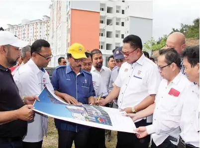  ??  ?? NOH (tiga kanan) menandatan­gani banting PPR Kg Ketiau sebagai gimik pelancaran ketika melawat ke tapak projek berkenaan kelmarin.