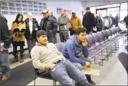  ?? Carol Kaliff / Hearst Connecticu­t Media ?? Will Dominic, left, waits with his friend Flavio Gonzalez, both of Danbury, for his turn at the Department of Motor Vehicles in Danbury in 2016. Gonzalez was at the DMV to transfer license plates.