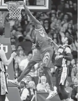  ?? Eric Christian Smith, The Associated Press ?? Rockets center Clint Capela dunks Wednesday night as Nuggets guard Jamal Murray looks on.