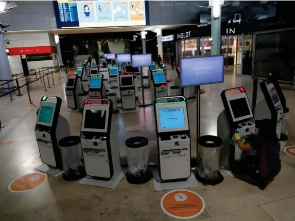  ?? (Reuters) ?? Self check-in machines are cleaned at Lisbon’s airport
